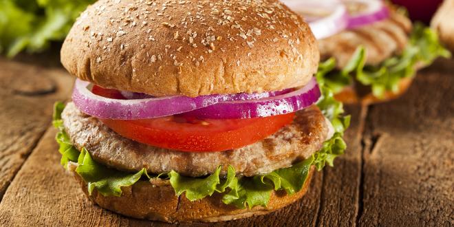 a homemade turkey-meat patty with lettuce, tomato, and onion