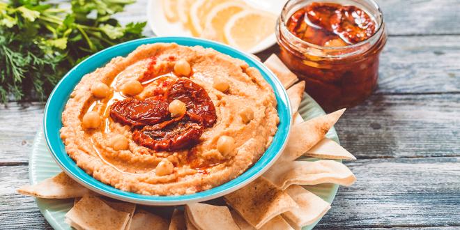 a plate of pita chips and a bowl of hummus