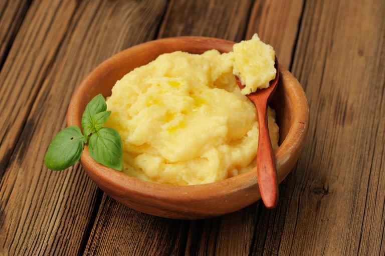 a bowl of cheesy polenta with basil