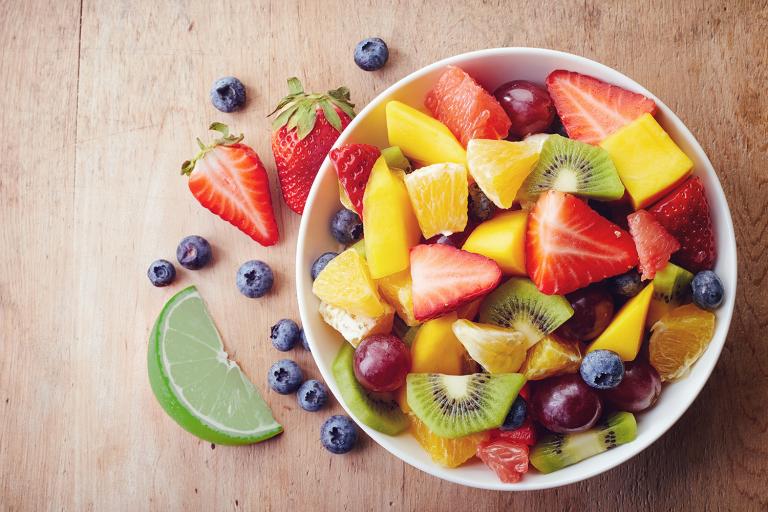 a bowl of fruit salad and a sliced lime